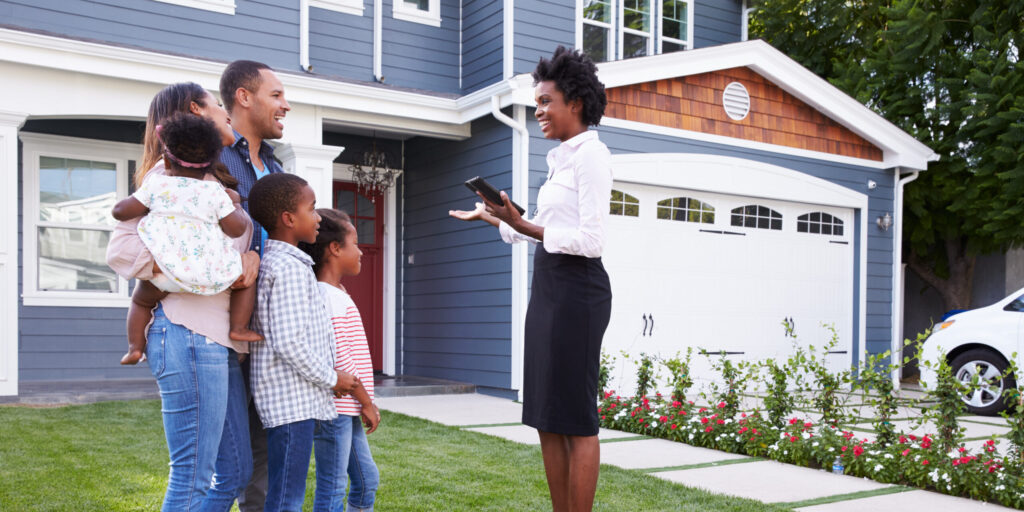 Real estate agent showing a family a house